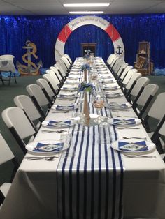 a long table is set up with plates and silverware for an ocean themed party