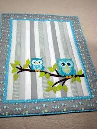 two blue owls sitting on a tree branch quilted onto a baby bedding set