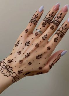 a woman's hand with henna tattoos on it