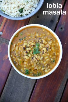 two bowls filled with beans and rice on top of a wooden table