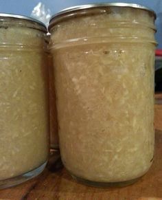 two jars filled with food sitting on top of a wooden table