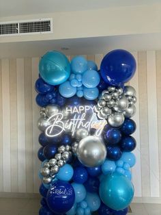 blue and silver balloons are arranged in the shape of a happy birthday sign on display