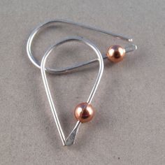 Small Everyday Earrings Sterling silver Copper Gold -fits standard piercings -1 inch -pair -2 gold filled, sterling and copper beads included that you can rotate on and off -nickel free hypoallergenic -backings included These earrings are handmade by me with hard temper wire to ensure they retain their shape. Polished and rounded earring ends prevent irritation when worn. Simple sleeper style earrings with spring to them provides you with a pair of earrings that will last you for many years. The Minimalist Silver Copper Earrings, Gold Bridesmaid Jewelry, Wire Jewelry Earrings, Silver Wire Earrings, Bijoux Fil Aluminium, Geode Earrings, Earring Hook, Silver Jewelry Design, Earrings Inspiration