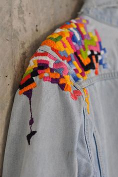 a colorful jacket hanging up against a wall