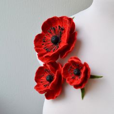 three red flowers on top of a white mannequin