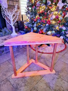 a wooden table sitting in front of a christmas tree