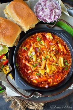 an image of a bowl of food on a plate with bread and vegetables next to it