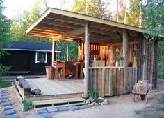 a small wooden cabin in the middle of a forest with steps leading up to it