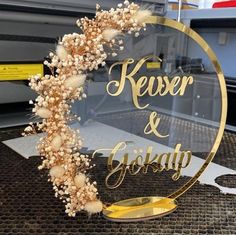 a glass sign that says keser & girsday on it with flowers in the middle