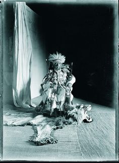 an old black and white photo of a woman sitting on the floor with her dog