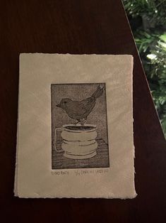 a drawing of a bird sitting on top of a table next to a christmas tree