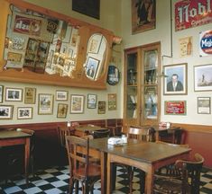 an empty restaurant with tables and chairs in front of pictures on the wall above them