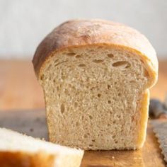 a loaf of bread sitting on top of a wooden cutting board next to a knife