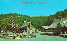 an old postcard shows people standing in front of a log cabin with a statue of a man riding a horse