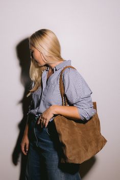 Introducing our Suede Tote: The Perfect Blend of Style and Functionality I designed this bag out of a need for a way to carry my laptop as the weather changes. I fell in love with this gorgeous caramel suede when I visited the tannery in Nairobi last year and knew it would be so perfect for fall. It's the perfect brown that feels golden and rich against black and is the perfect neutral tying together the color tones in your fall wardrobe. I like to wear my Sling Bag even while carrying The Tote Everyday Camel Bag For Fall, Chic Brown Bag With Suede Lining, Suede Bag With Leather Lining For Work, Classic Suede Shoulder Bag With Leather Lining, Chic Suede Shoulder Bag For Travel, Classic Suede Shoulder Bag For Work, Suede Satchel Work Bag, Chic Brown Shoulder Bag With Suede Lining, Suede Double Handle Bag For Work