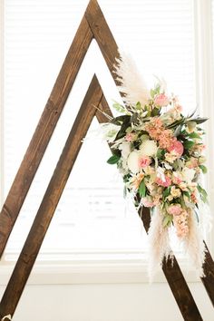 a wedding arch decorated with flowers and feathers