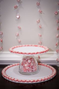 a cake stand with pink and red candy canes on it