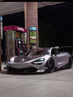 a silver sports car parked in front of a gas station