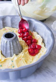 someone is adding cherries to the batter in a pan