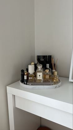 a white table topped with lots of bottles and containers on top of it next to a mirror