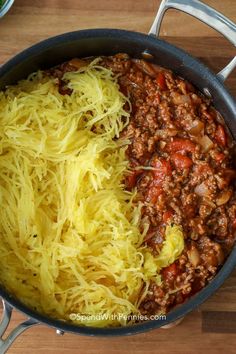 spaghetti and ground beef in a skillet ready to be cooked