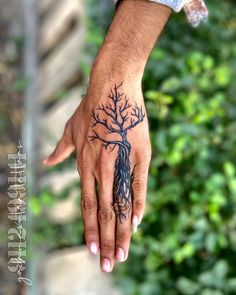 a hand with a tree tattoo on it