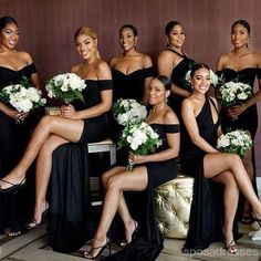 a group of women in black dresses posing for a photo with white flowers and bouquets