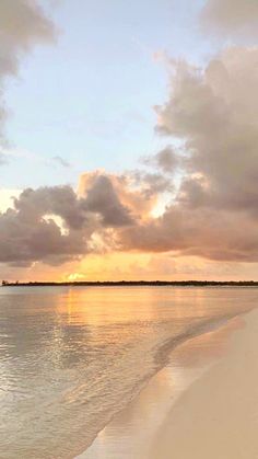 the sun is setting over the water at the beach