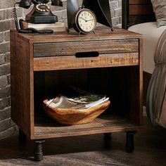 an old wooden table with a clock and telephone on it