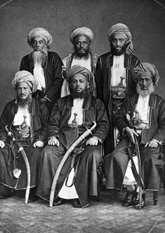 an old black and white photo of men in turbans