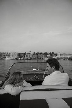 a man and woman riding in a boat on the water