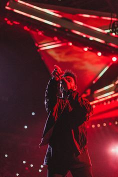 a man standing on top of a stage holding a microphone