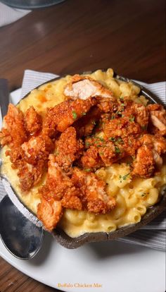 a plate filled with macaroni and cheese covered in meat