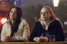 two women sitting next to each other at a bar