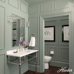 a white sink sitting under a bathroom mirror next to a toilet