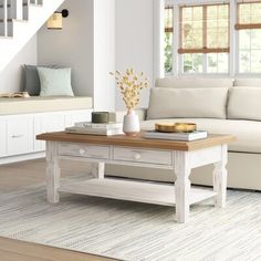 a living room with a couch, coffee table and stairs leading to the second floor