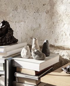 a stack of books sitting on top of a table next to vases and sculptures