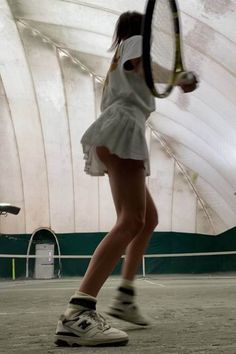 a woman holding a tennis racquet on top of a tennis court