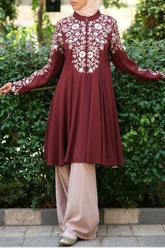 Jawhara Embroidered Tunic Maroon. An array of flowers wraps gently around the bodice and arms drawing attention towards the face with the Jawhara Embroidered Tunic. Falling effortlessly with a generous cut of fabric that creates a rippling effect in the lower section, this tunic encompasses femininity at its finest. #tunik #hijabfashion #islamicclothing #tunikhijabstyle #muslimfashion #ootdhijab #tunikmodern #casualstyle #afflink #womensfashion #tunics #moslemfashion #blouse #springfashion Tunik Hijab Style, Arms Drawing, Moslem Fashion, Islamic Clothing, Clothing Retail, Dresses 2020, Shank Button, Embroidered Tunic, Women Tunic Tops