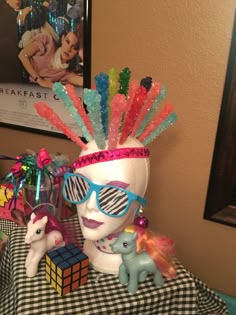 a table topped with toys and glasses on top of a checkered table cloth