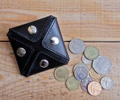 a wallet and some coins on a wooden table