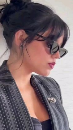 a woman wearing sunglasses and a suit jacket