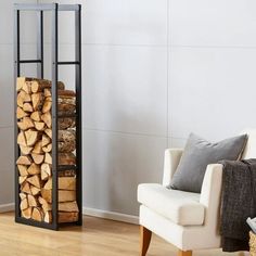 a white chair sitting in front of a stack of firewood on top of a hard wood floor