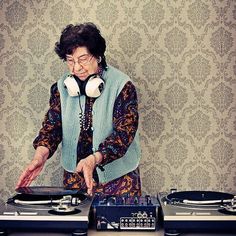 an old woman is djing at a turntable with headphones on her ears and the words, it's never too late to be who you were always meant to be