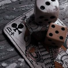 two dices sitting on top of each other on a playing card with skulls around them