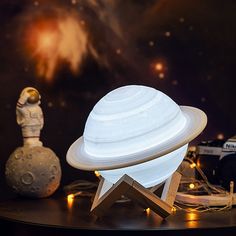 a small white object sitting on top of a table next to a toy rocket ship