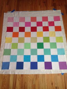 a multicolored quilt is laying on the floor