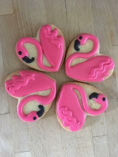 four decorated cookies in the shape of pink flamingos