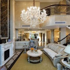 an elegant living room with chandelier and couches