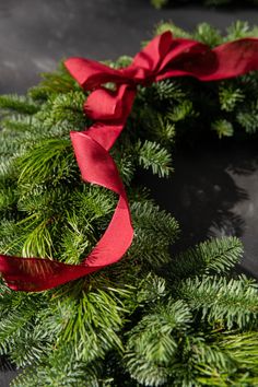 a close up of a wreath with red ribbon